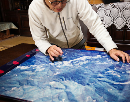 山林の航空写真を指し示しながら